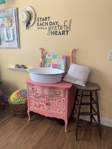 A charming vintage pink cabinet adorned with a cheerful quote, perfect for adding a touch of warmth to any room.