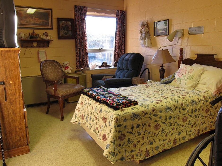 Cozy bedroom with floral bedding and comfortable seating arrangements.