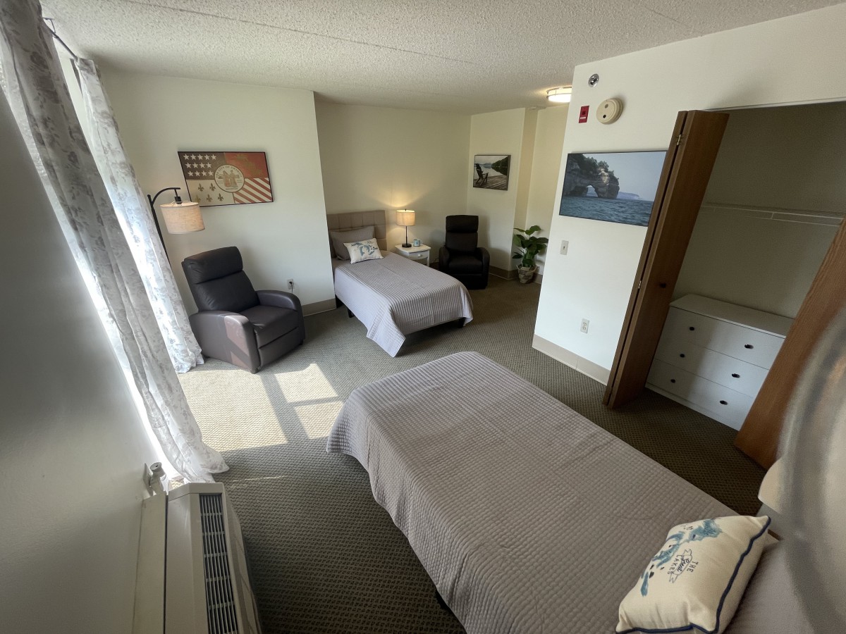 A cozy bedroom with twin beds and comfortable seating.