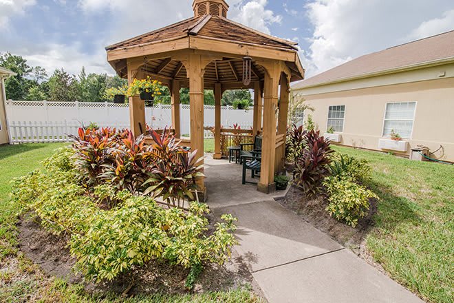 A charming gazebo surrounded by lush plants in a well-maintained garden.