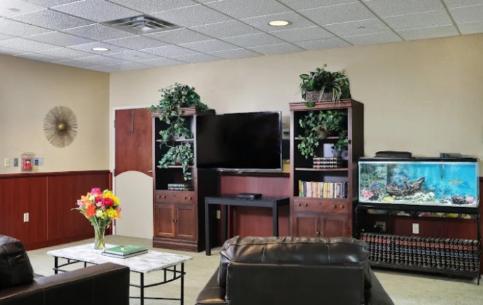 A cozy living room with a television, bookshelves, and comfortable seating.