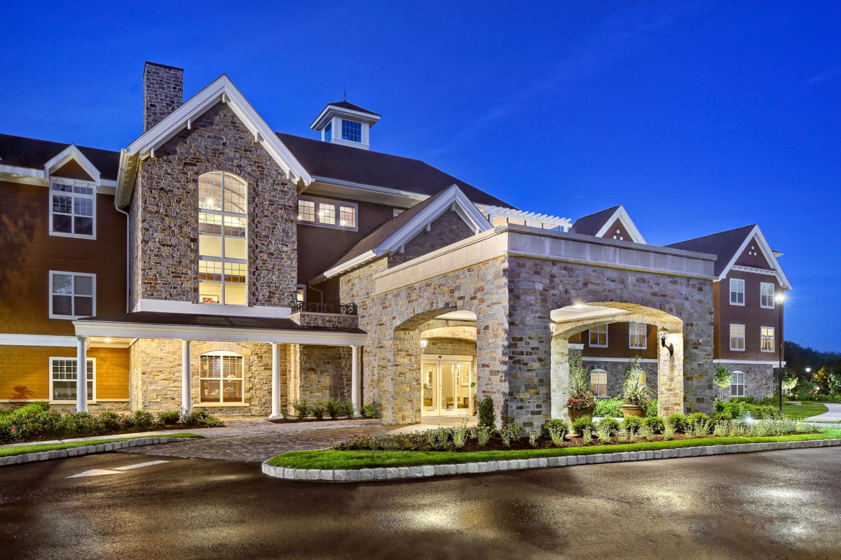 A beautifully lit building with a stone facade and welcoming entrance at night.