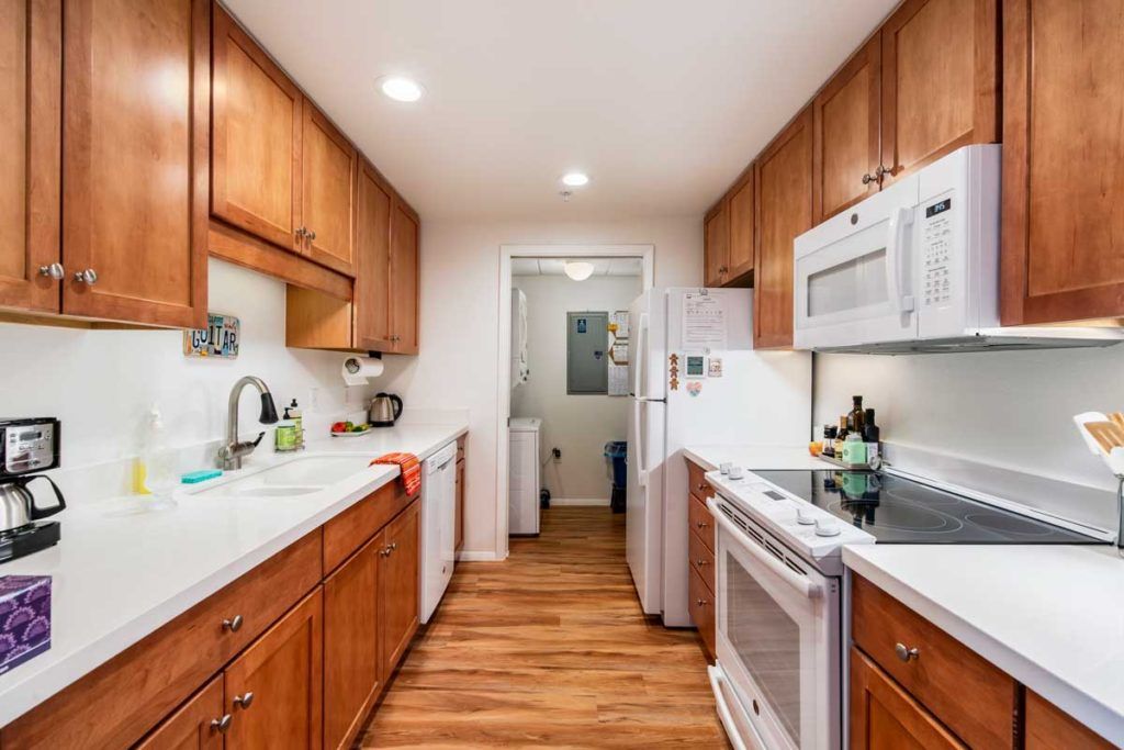 A modern kitchen with wooden cabinets and white appliances.