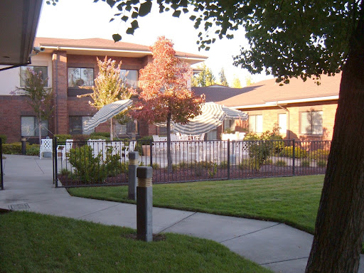 A well-maintained residential area featuring a building surrounded by greenery and a pathway.