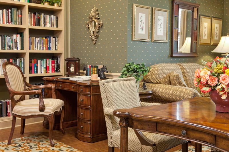 A traditional office interior with classic wooden furniture and a cozy seating area.