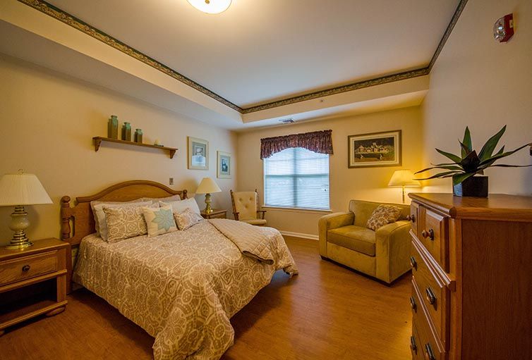 A cozy and warmly lit bedroom with a comfortable bed, armchair, and decorative elements.