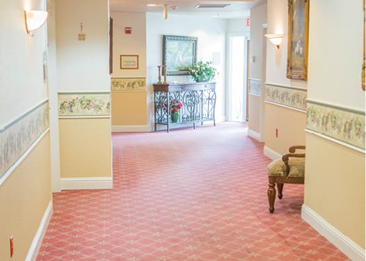 Brightly lit hallway with patterned carpet and decorative furnishings.
