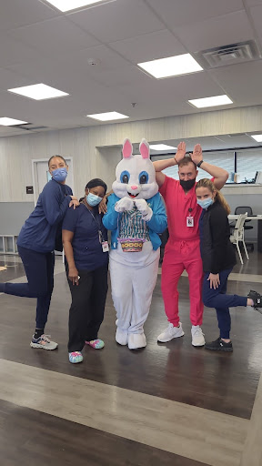 Healthcare workers posing for a photo with a friendly bunny mascot.
