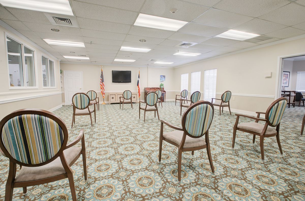An empty meeting room with chairs arranged for social distancing.