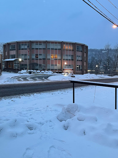 A snow-covered scene featuring a circular building illuminated in the evening light.