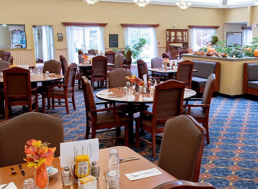 An empty dining room with neatly arranged tables and chairs, ready for guests.