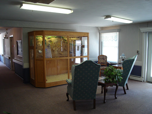 A cozy living room space featuring comfortable seating and a display case.