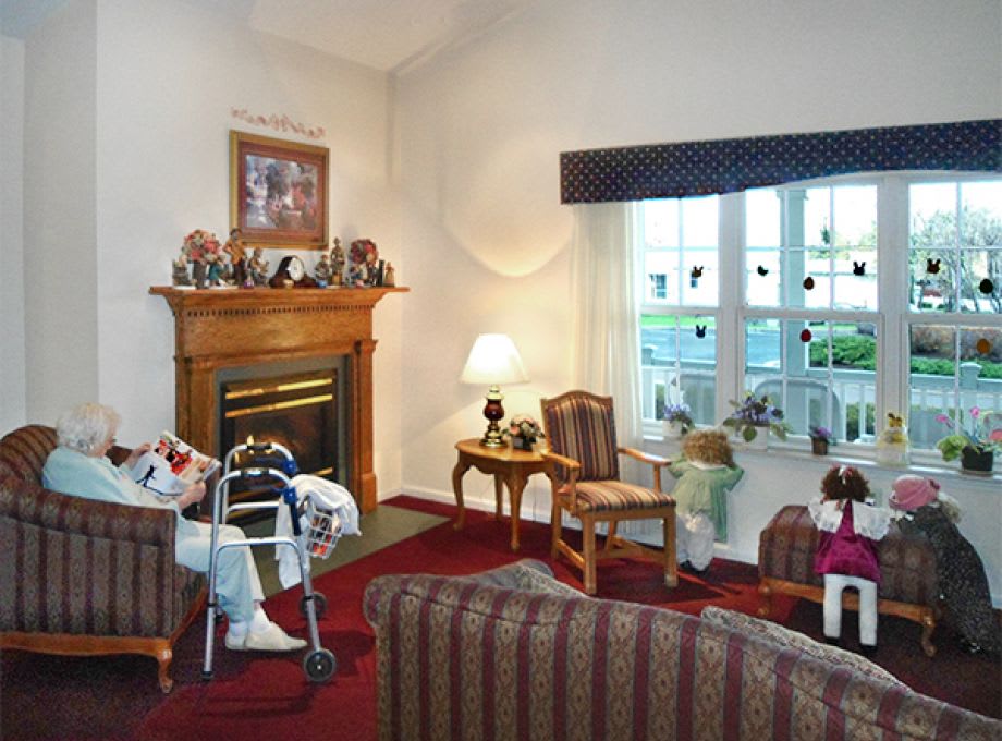 A cozy living room featuring a fireplace, armchairs, and decorative items.