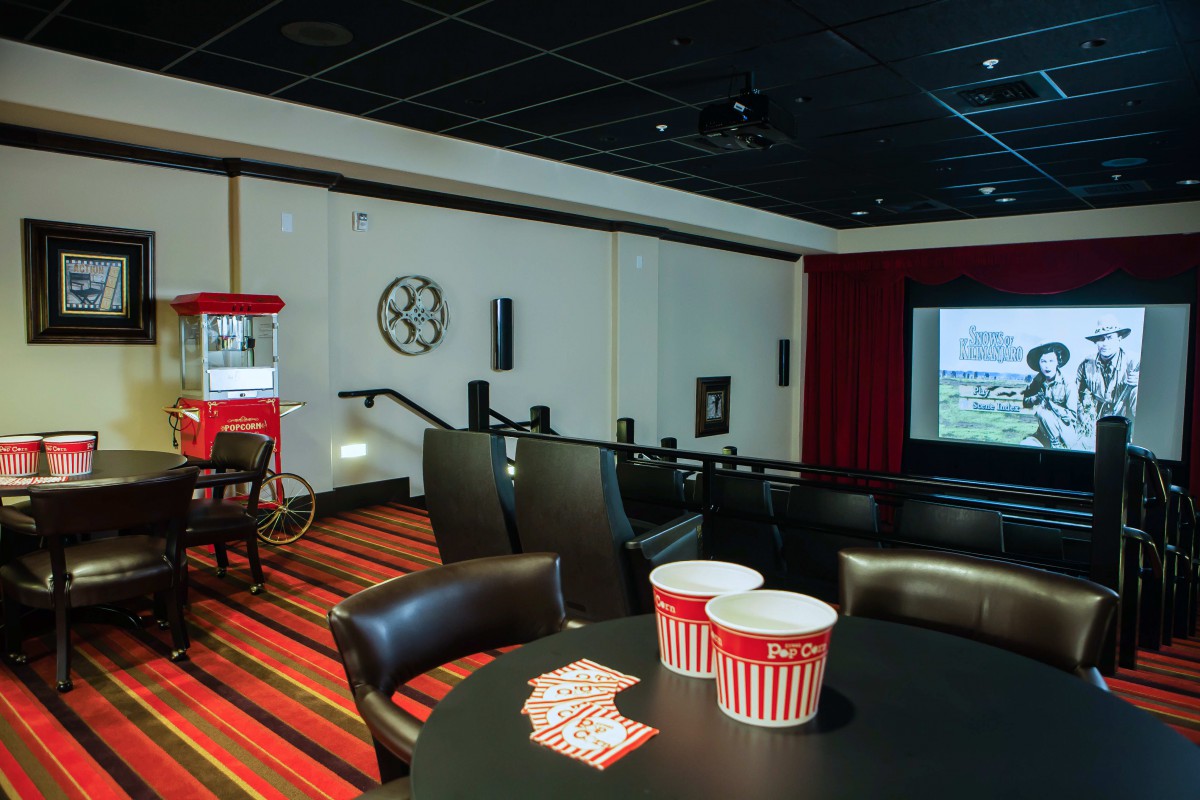 A cozy home theater setup with a large projector screen, comfortable seating, and a popcorn machine.