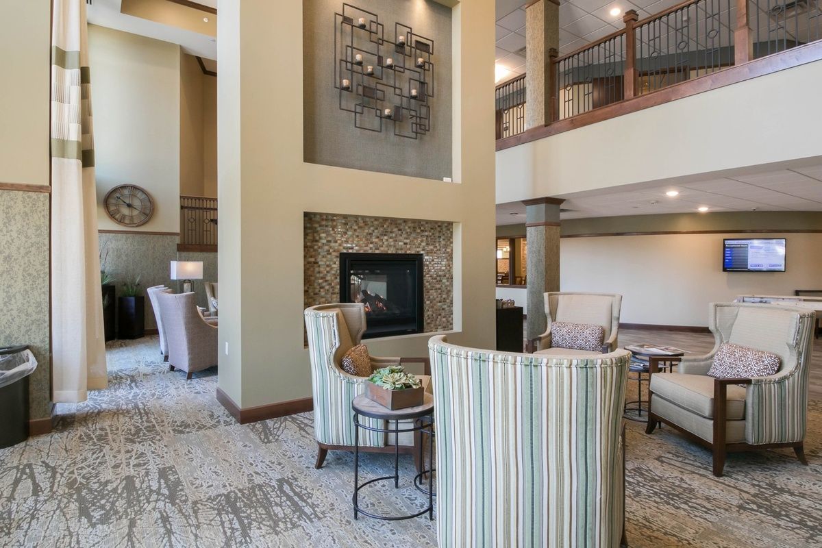A modern living room with high ceilings, featuring a fireplace and stylish seating area.