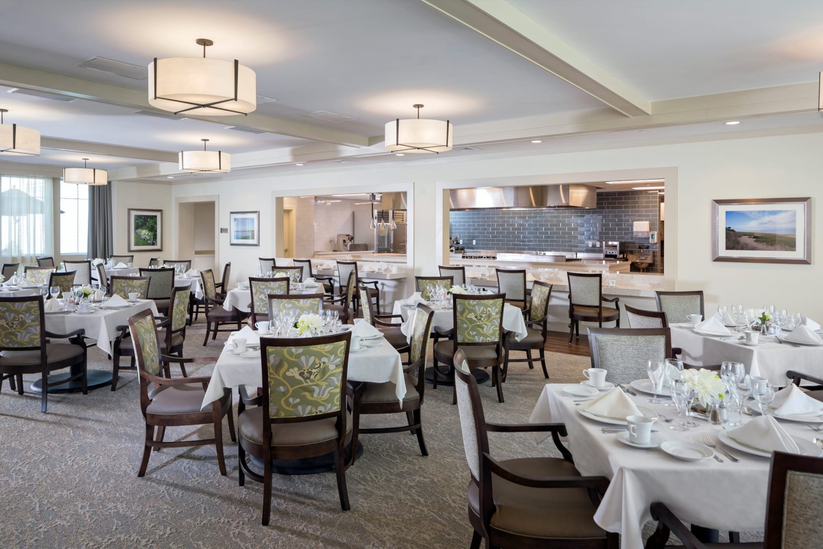 A spacious dining area with neatly arranged tables and chairs, featuring elegant decor.