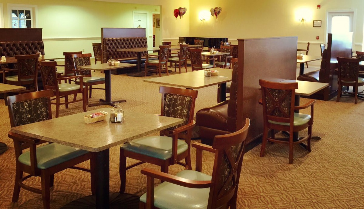 An empty restaurant dining area with neatly arranged tables and chairs.