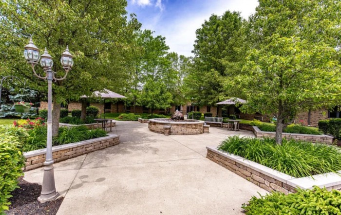 A tranquil outdoor patio with benches and greenery, providing a serene setting for relaxation.