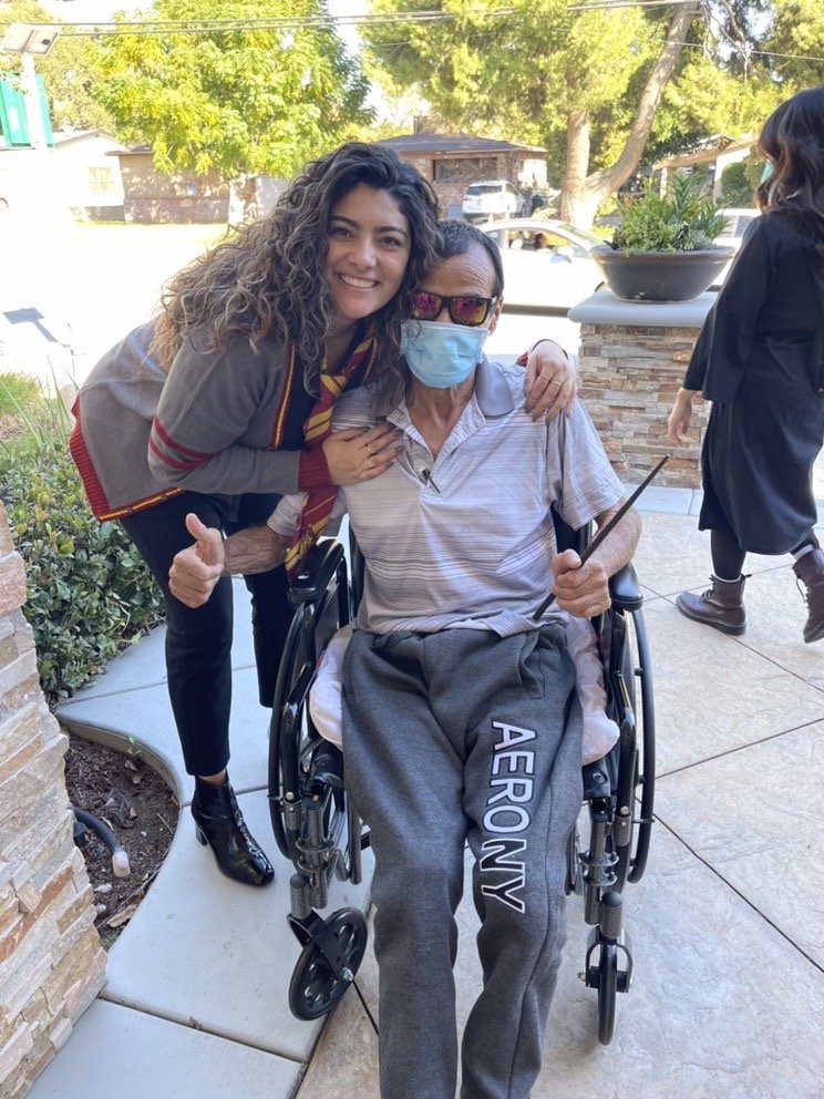 A cheerful moment outdoors with a person in a wheelchair and two companions.
