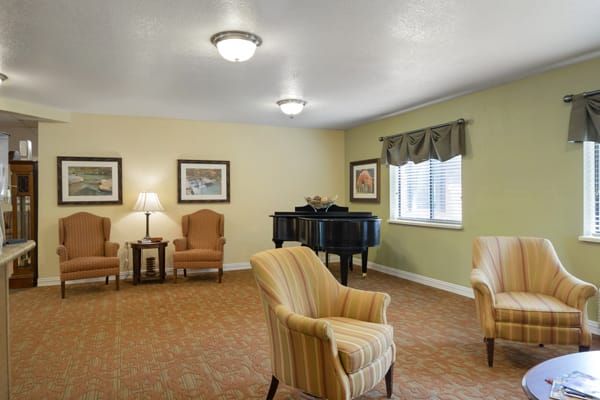 A cozy living room with a piano and seating area.