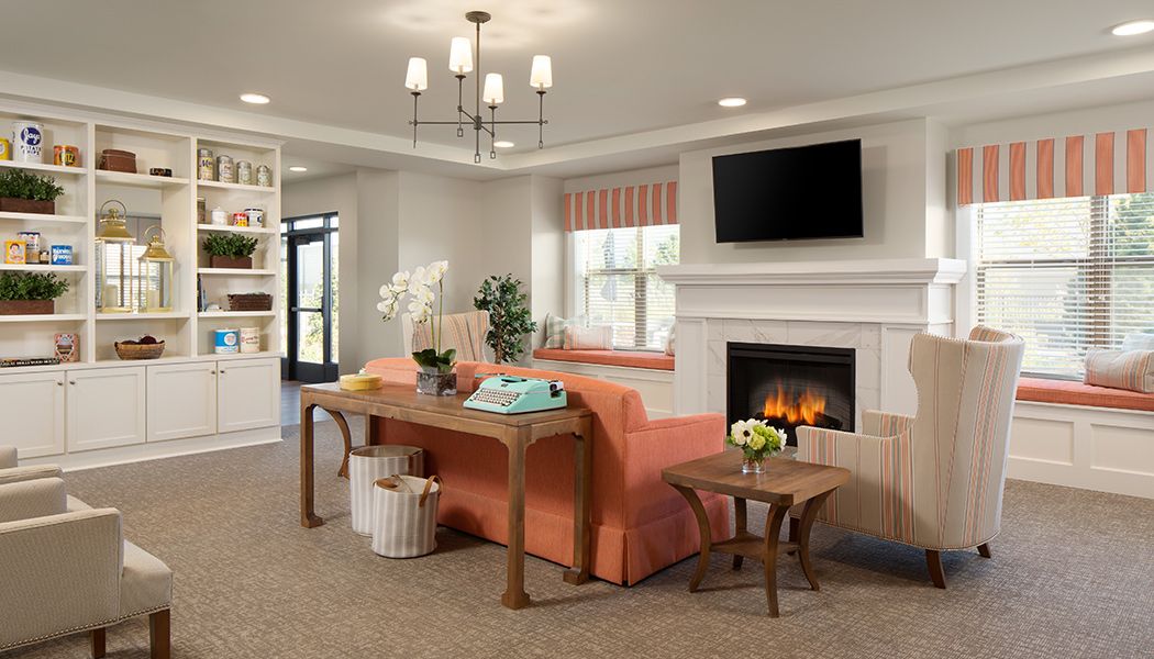 A cozy and modern living room featuring a comfortable sofa, elegant chandelier, and a warm fireplace.