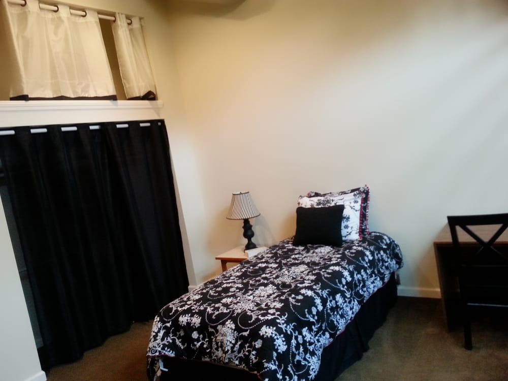 A cozy bedroom with a single bed and matching black and white decor.