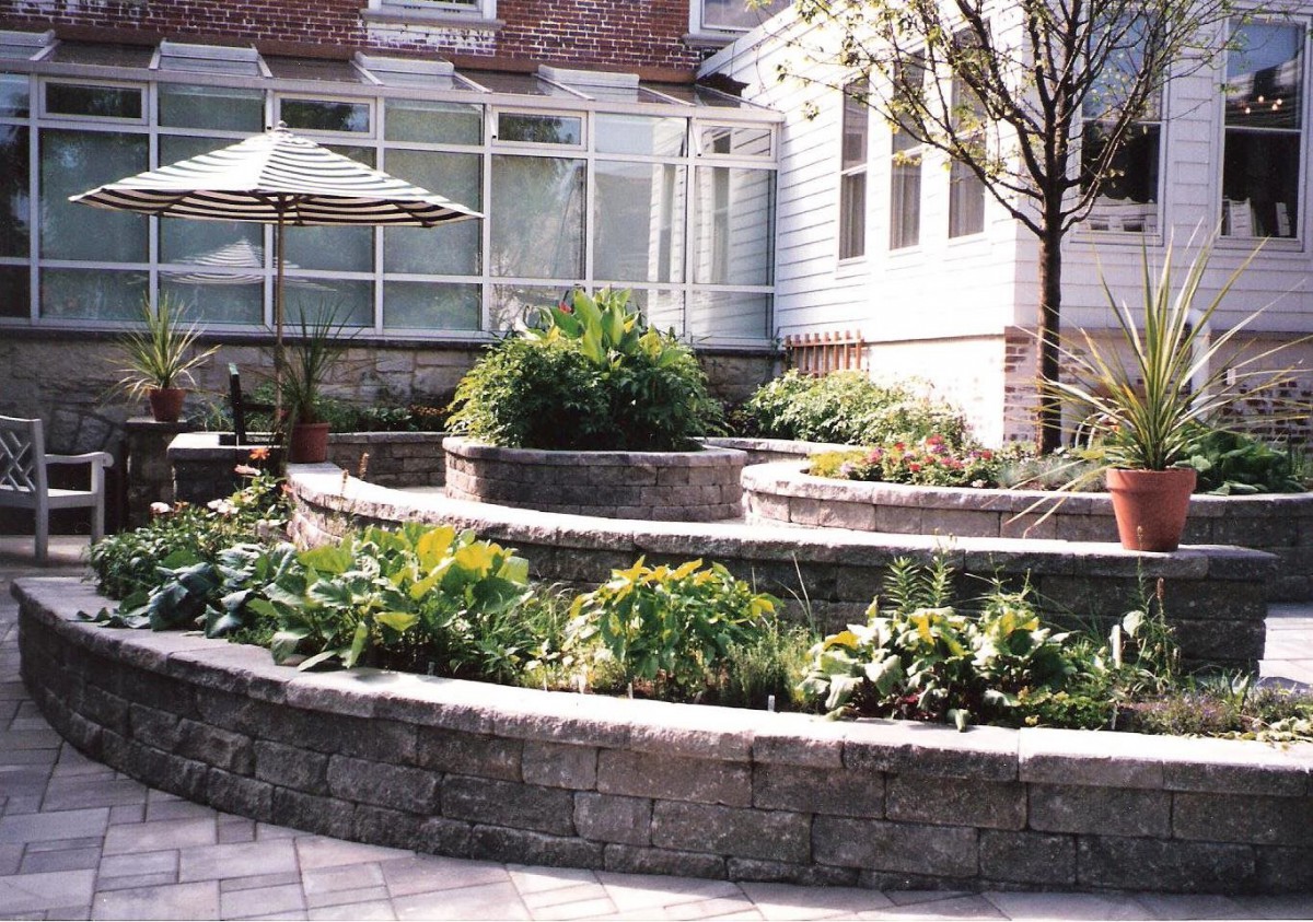 A terraced garden with stone retaining walls and lush greenery.