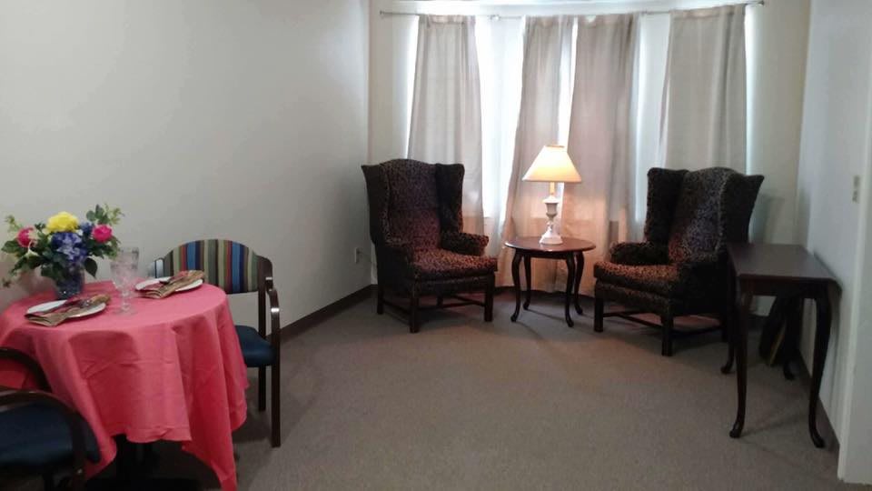 A cozy living room corner with two armchairs and a lamp on a side table.