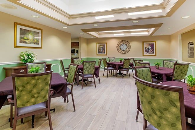 A spacious dining room with elegantly arranged tables and chairs, adorned with decorative elements and indoor plants.