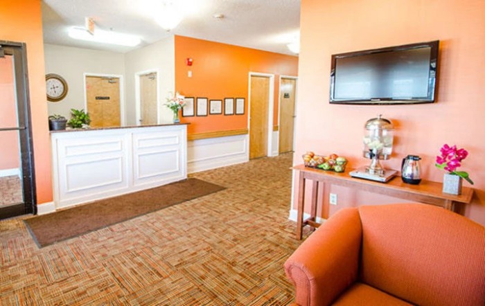 A welcoming lobby with orange accents and comfortable seating.