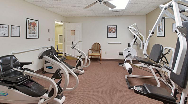 A small fitness room equipped with exercise machines like treadmills and stationary bikes.