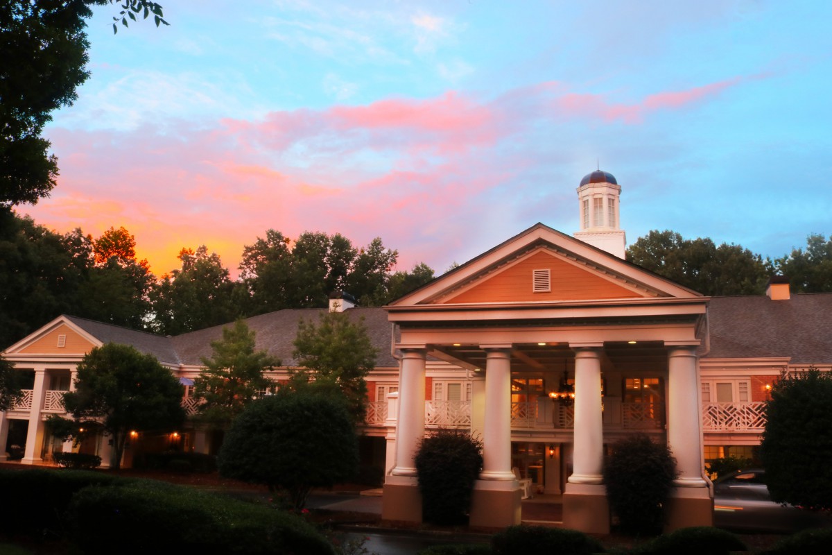 A classical-style building with columns under a colorful sunset sky.