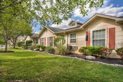 A charming suburban house with a well-maintained lawn and trees.