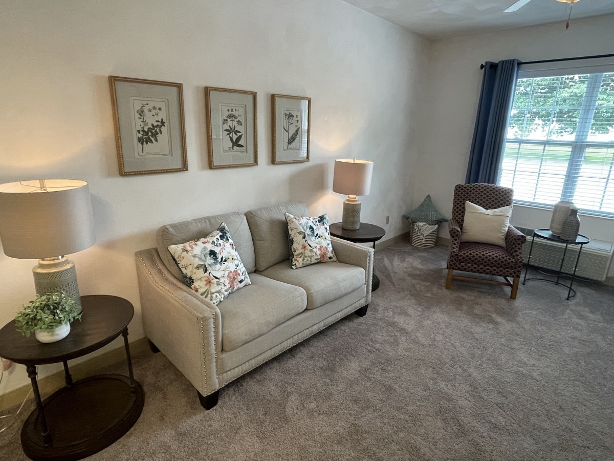 A cozy living room with a beige sofa, armchair, and tasteful decor.