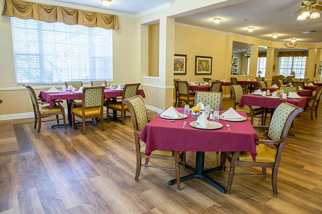 A neatly arranged dining room with tables set for guests.