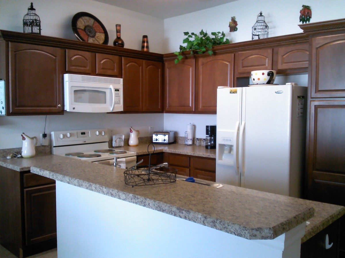 A modern kitchen with wooden cabinets, a microwave, and a refrigerator.