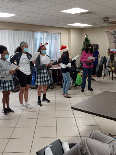 Local students perform holiday songs for residents at a senior center, spreading joy and festive spirit.