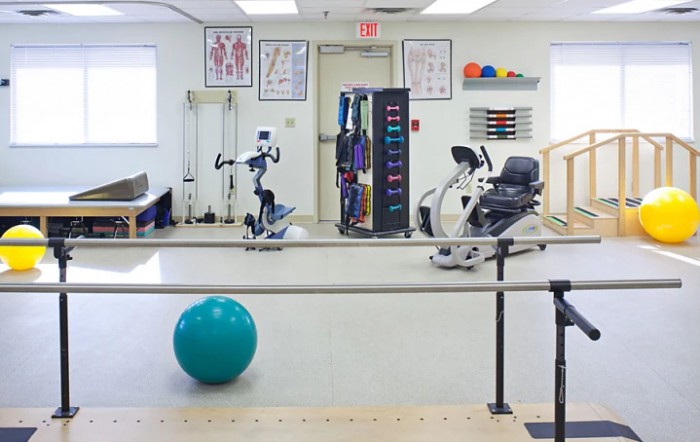 A physical therapy room equipped with various exercise machines and tools.