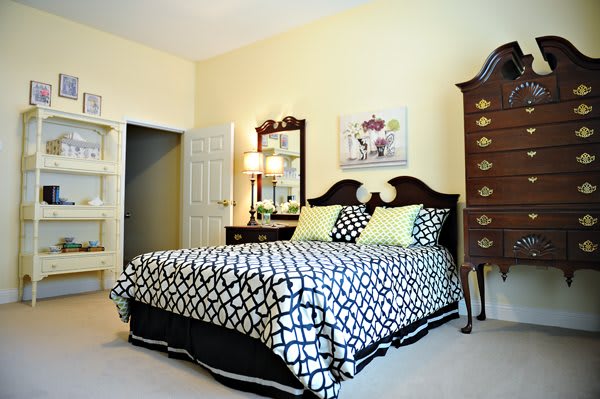 A cozy bedroom with a patterned bedspread and elegant furniture.