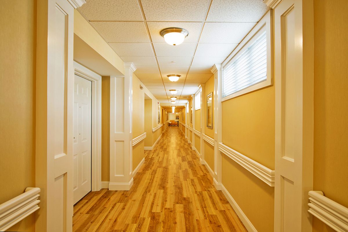 A long hallway with wooden flooring and soft lighting.