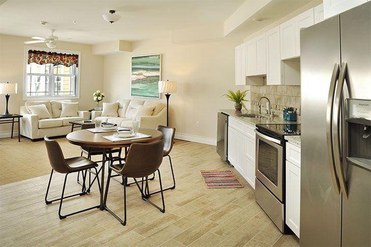 A modern open floor plan kitchen and living room with a dining area.