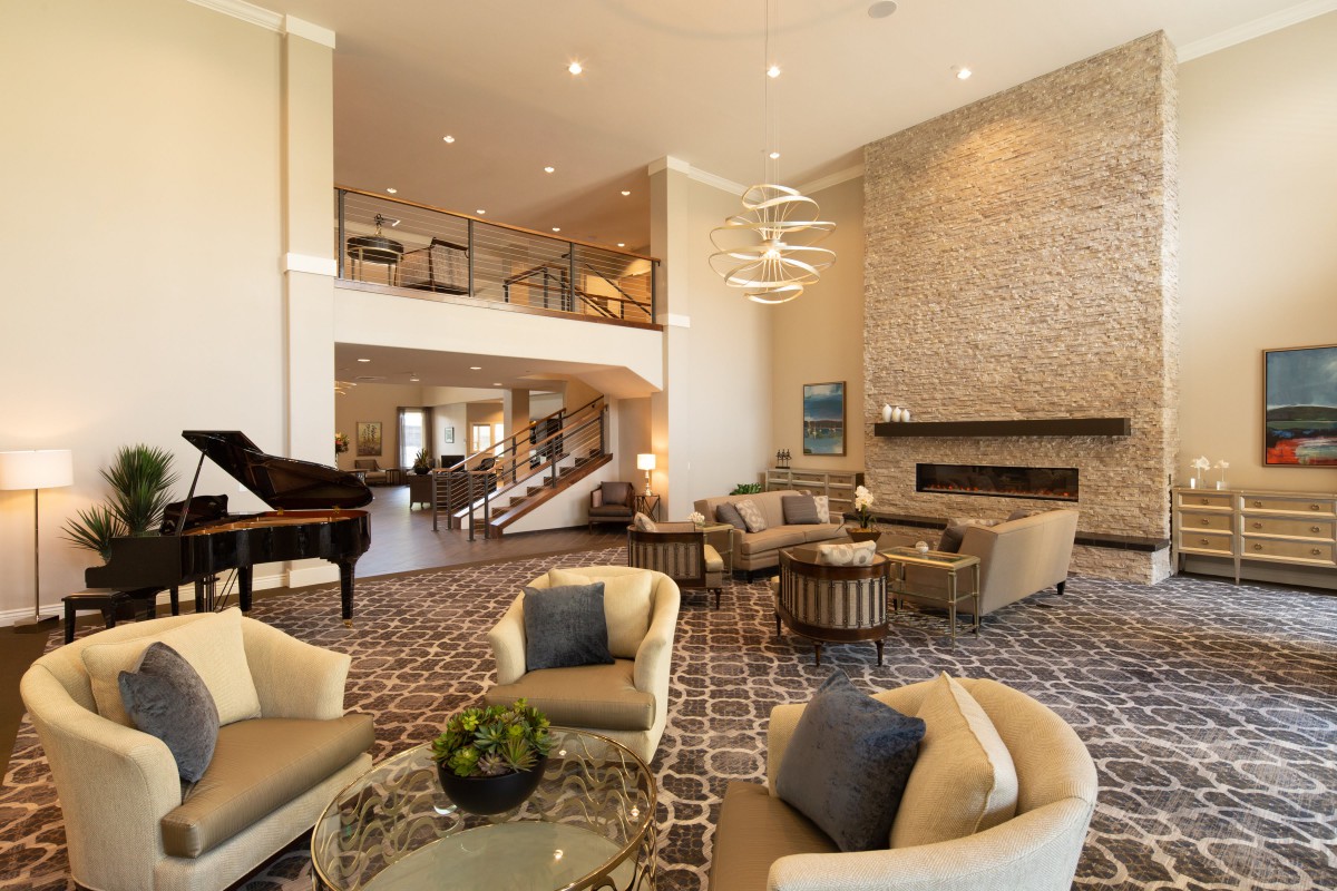 A spacious and modern living room with luxurious furnishings and a grand piano.
