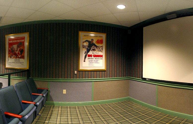 A cozy cinema room featuring a vintage movie poster and theater-style seating.