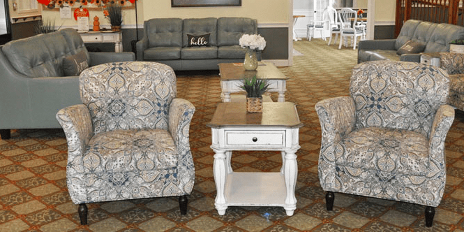 A cozy living room setup with patterned armchairs, a central coffee table, and a comfortable sofa in the background.