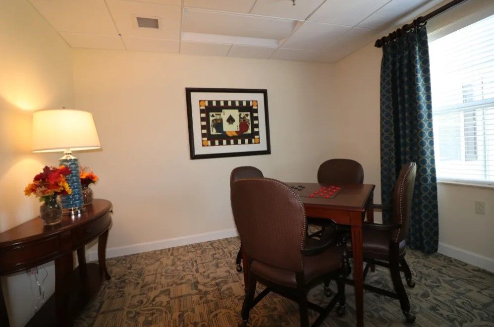 A small meeting room with a table, chairs, and artwork on the wall.