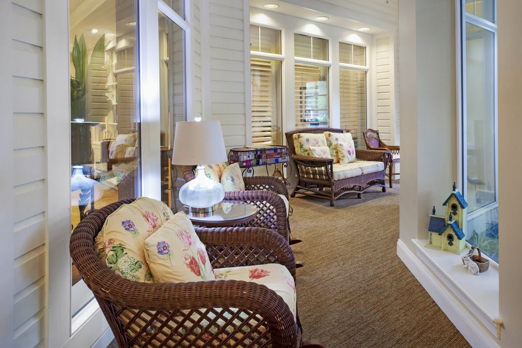 A cozy living room with wicker furniture and decorative pillows.