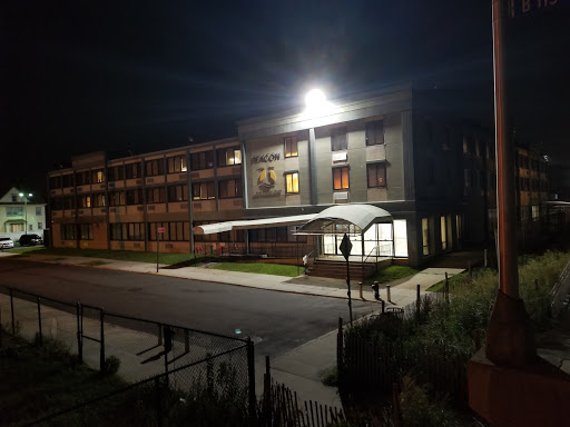 A well-lit modern building at night, showcasing its architectural design.
