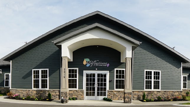 A commercial building with a prominent entrance and arched roof design.