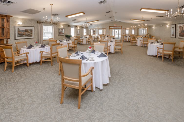 An elegantly decorated dining room with neatly arranged tables and chairs, ready for guests.