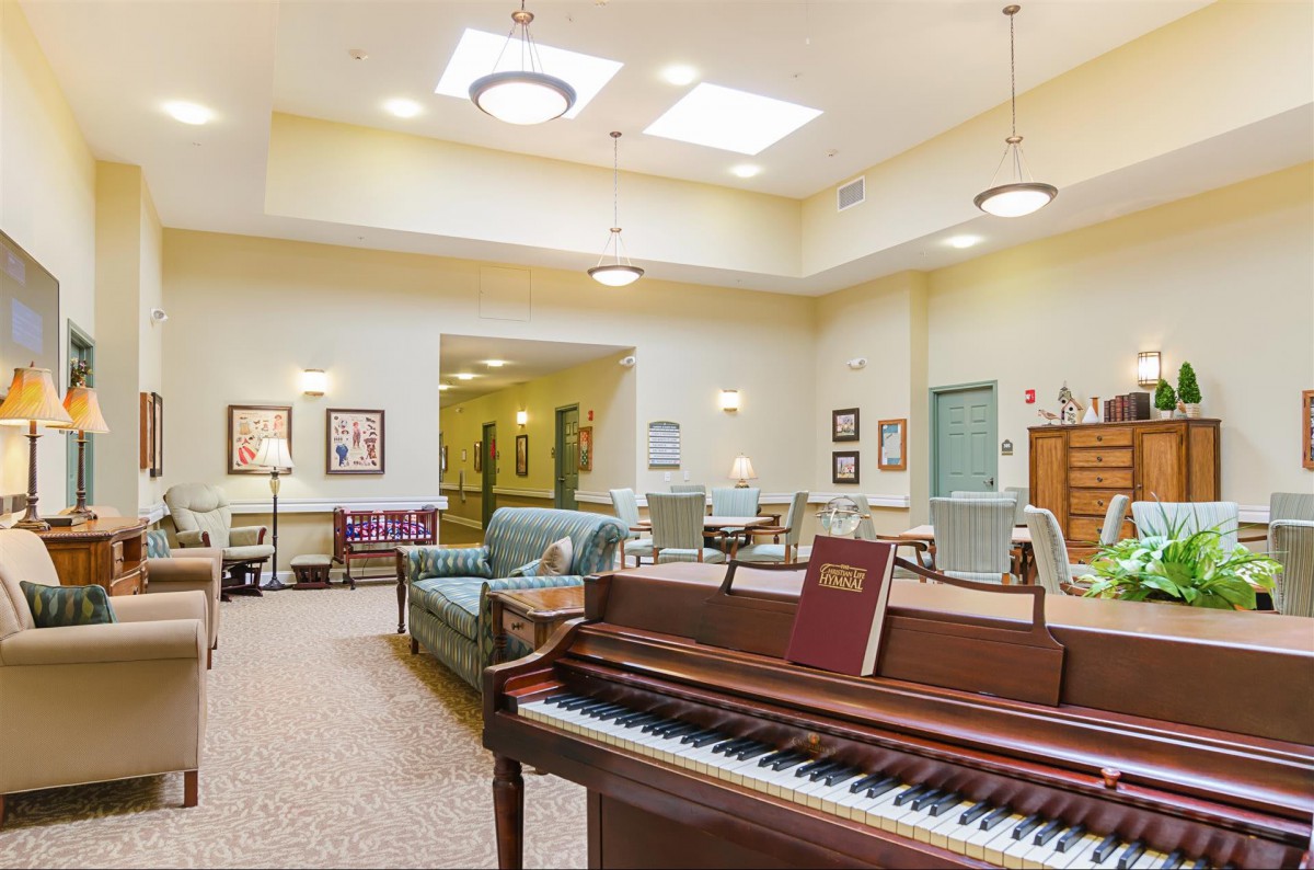 A cozy lounge area with a piano and comfortable seating, featuring soft lighting and elegant decor.